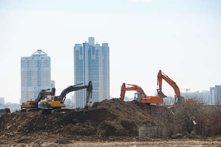Four excavators work on a constuction siteの写真素材
