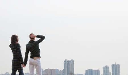 Two young girls looking to a big city panoramaの写真素材