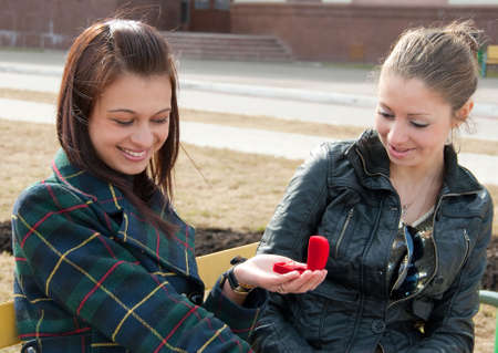 One girl shows to other ring in red boxの写真素材