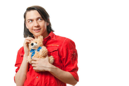 Young guy with his loved  from childhood toy - teddy bear. Isolated over white in studio.の写真素材