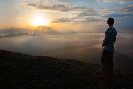 Man at the peak watching the sunの写真素材