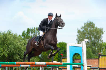 Jockey jumps over a hurdle at the competitionの写真素材