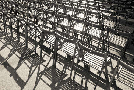 Lots of wooden chairs standing in a row. Monochrome image.の写真素材