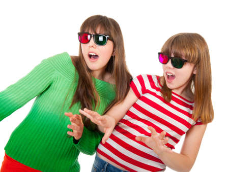 Sisters having fun while watching 3D movie isolated on white backgroundの写真素材