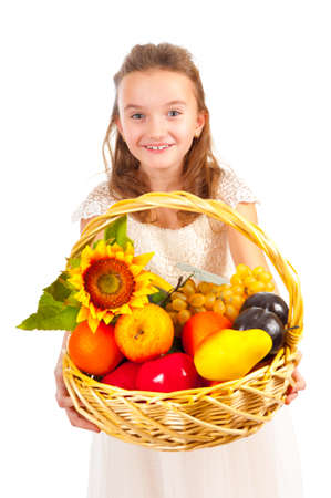 Girl holding basket full of fresh fruit isolated on whiteの写真素材