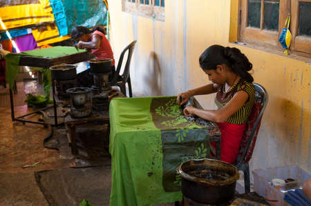 KANDY, SRI LANKA - MARCH 31: Two women, traditional batik painter working in the batik factory on...