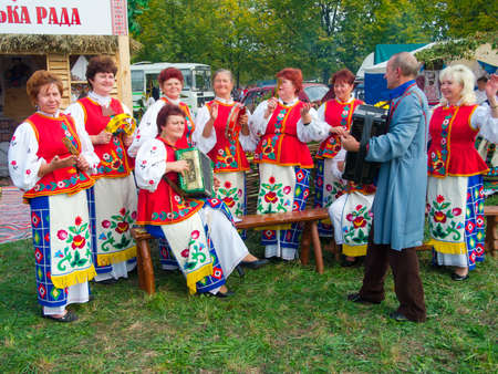 SUMY, UKRAINE - SEPTEMBER 22: Unidentified folk music band performs in traditional village background at annual agro exhibition SUMY-2012 on September 22, 2012 in Sumy, Ukraineのeditorial素材