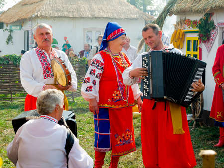 SUMY, UKRAINE - SEPTEMBER 22: Unidentified folk music band performs in traditional village background at annual agro exhibition SUMY-2012 on September 22, 2012 in Sumy, Ukraineのeditorial素材