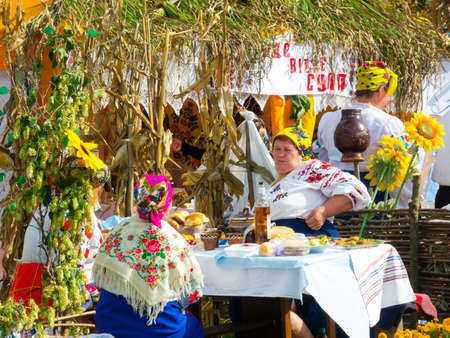 SUMY, UKRAINE - SEPTEMBER 22: Women wearing historical costume posing in traditional village background on annual agro exhibition SUMY-2012 on September 22, 2012 in Sumy, Ukraineのeditorial素材