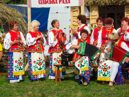 SUMY, UKRAINE - SEPTEMBER 22: Unidentified folk music band performs in traditional village background at annual agro exhibition SUMY-2012 on September 22, 2012 in Sumy, Ukraineのeditorial素材