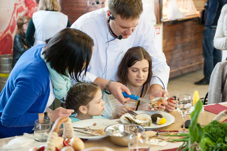 MOSCOW - APRIL 13: Chef Andrew Kuspits shows how to properly prepare and eat seafood at culinary master class "Taste Lesson number 5: Seafood" in Dorogomilovskij market on April 6, 2013 in Moscow.のeditorial素材