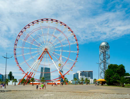 BATUMI, GEORGIA - JULY 7: Ferris wheel and Tower Alphabet on July 7, 2013 in Batumi, Georgia. In recent years Batumi is a lot of modern construction for tourism developmentのeditorial素材
