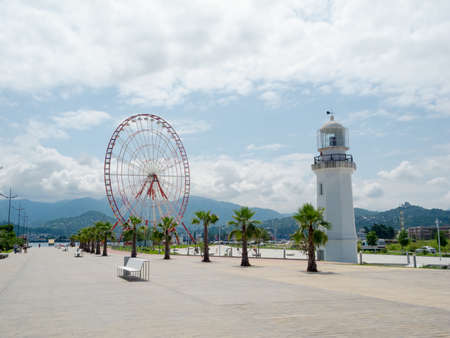 BATUMI, GEORGIA - JULY 7: Ferris wheel and lighthouse on the seafront on July 7, 2013 in Batumi, Georgia. In recent years Batumi is a lot of modern construction for tourism developmentのeditorial素材
