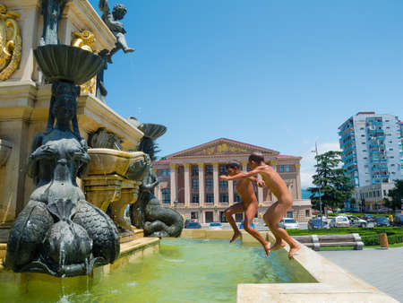 BATUMI, GEORGIA - JULY 7: Naked street boys splashing in the Neptune fountain on July 7, 2013 in Batumi, Georgia. Street children in the streets of modern Batumi give the city a special touchのeditorial素材