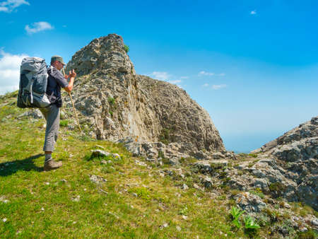 Hiker on the top takes picture of landscapeの写真素材
