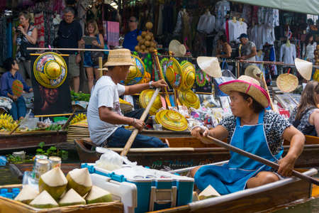 RATCHABURI, THAILAND - MARCH 24: Local peoples sell fruits, food and souvenirs at famous tourist attraction Damnoen Saduak floating market on March 24, 2014 in Ratchaburi, Thailand.のeditorial素材