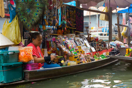 RATCHABURI, THAILAND - MARCH 24: Local peoples sell fruits, food and souvenirs at famous tourist attraction Damnoen Saduak floating market on March 24, 2014 in Ratchaburi, Thailand.のeditorial素材