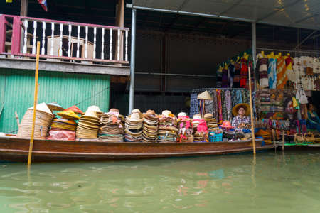 RATCHABURI, THAILAND - MARCH 24: Local peoples sell fruits, food and souvenirs at famous tourist attraction Damnoen Saduak floating market on March 24, 2014 in Ratchaburi, Thailand.のeditorial素材