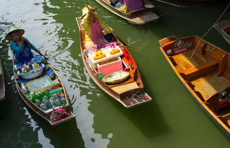 RATCHABURI, THAILAND - MARCH 24: Local peoples sell fruits, food and souvenirs at famous tourist attraction Damnoen Saduak floating market on March 24, 2014 in Ratchaburi, Thailand.のeditorial素材