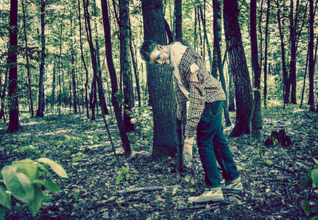 Man zombie walking dead outdoors. Dark lighting. Color was changed to emphasize the atmosphere of horror.の写真素材