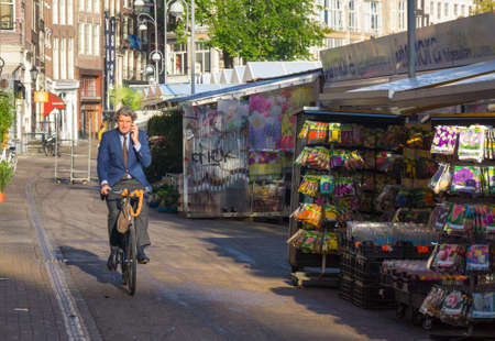 AMSTERDAM - AUGUST 29: Unidentified man rides a bike to work in the morning on August 29, 2014 in Amsterdam.のeditorial素材