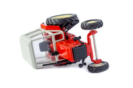 Toy tractor lying on its side isolated model on whiteの写真素材