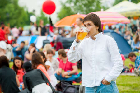 MOSCOW - JUNE 20, 2015: Young woman drinks beer on XII International Jazz Festival "Usadba Jazz" in Tsaritsyno Park on June 20, 2015 in Moscowのeditorial素材