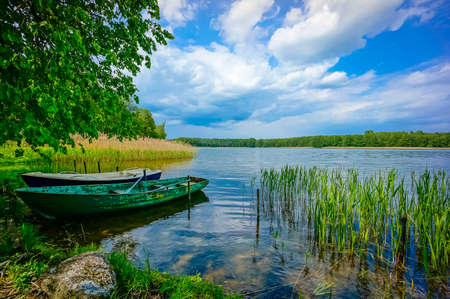 Pond landscape with boats at foregroundの写真素材