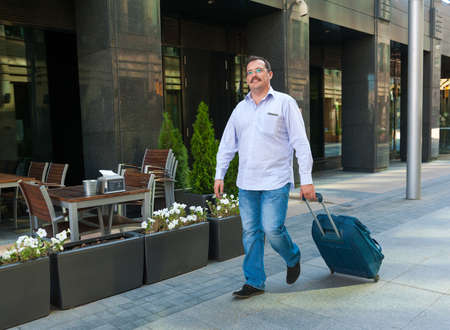 Middle age businessman walking on a city streetの写真素材