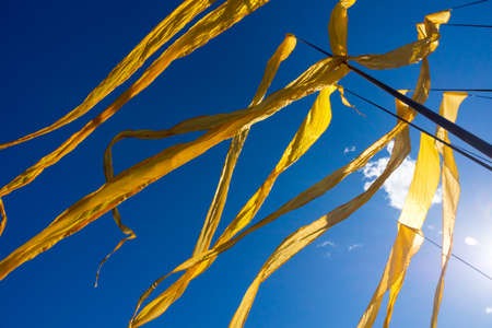 Yellow ribbon flags fluttering in the windの写真素材