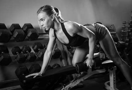 Young muscular woman doing workout at the gym