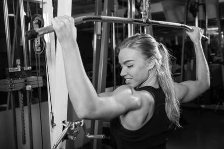 Young muscular woman doing workout at the gym
