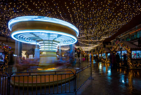 Merry-go-round carousel at evening at Christmas Fairの写真素材