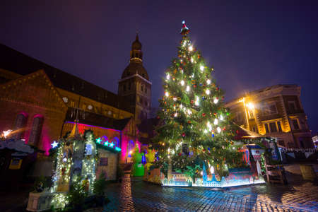 RIGA, LATVIA - DECEMBER 20, 2015: People visit Christmas Fair in old town at evening on December 20, 2015 in Riga, Latviaのeditorial素材