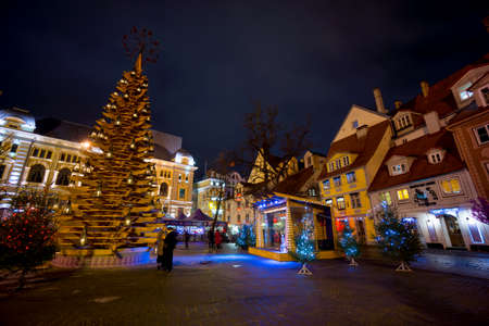 RIGA, LATVIA - DECEMBER 20, 2015: People visit Christmas Fair in old town at evening on December 20, 2015 in Riga, Latviaのeditorial素材