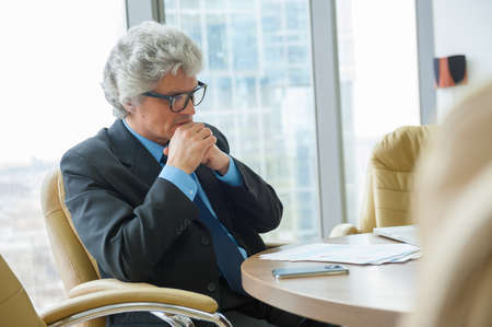Mature business man works with docs in modern officeの写真素材