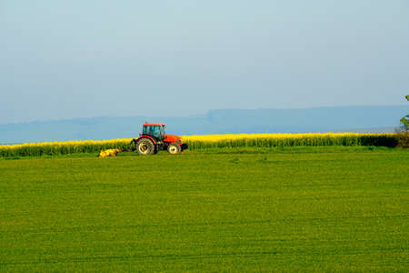 Agricultural tractor working in a fieldの写真素材