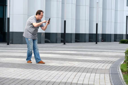 Man playing a geolocation game at the modern city background