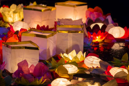Floating paper lanterns on the water at nightの写真素材