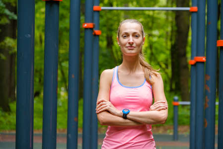 Young slim woman sports portrait on the training ground in a park