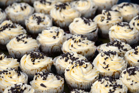 Many muffins with white creme and chocolateの写真素材