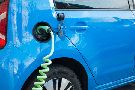 Modern electric car connected to charge stationの写真素材