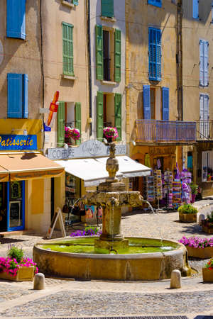 Valensole, France - July 4, 2016: Central square with fountain and private shops at day timeのeditorial素材