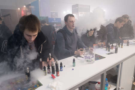 Moscow, Russia - December 9, 2016: People attend Vapexpo Moscow 2016 exhibition which presents new modern vape gadgets, liquids and flawoursのeditorial素材