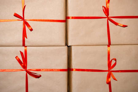 Gifts in brown paper, tied with a red ribbonの写真素材