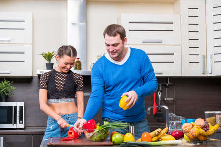 Young couple having fun in the kitchen preparing dinnerの写真素材