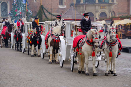 Krakow, Poland - December 19, 2016: Carriages for riding tourists on the background of Mariacki...
