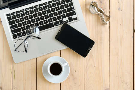 Wooden desk with various gadgets and accessories, top viewの写真素材