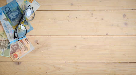 Banknotes different countries on the wooden table under the glassesの写真素材
