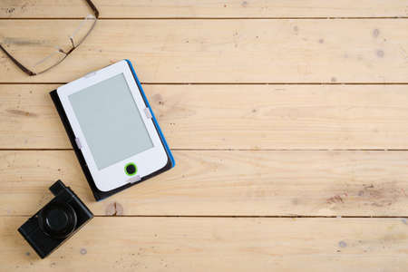 Wooden desk with various gadgets and accessories, top view